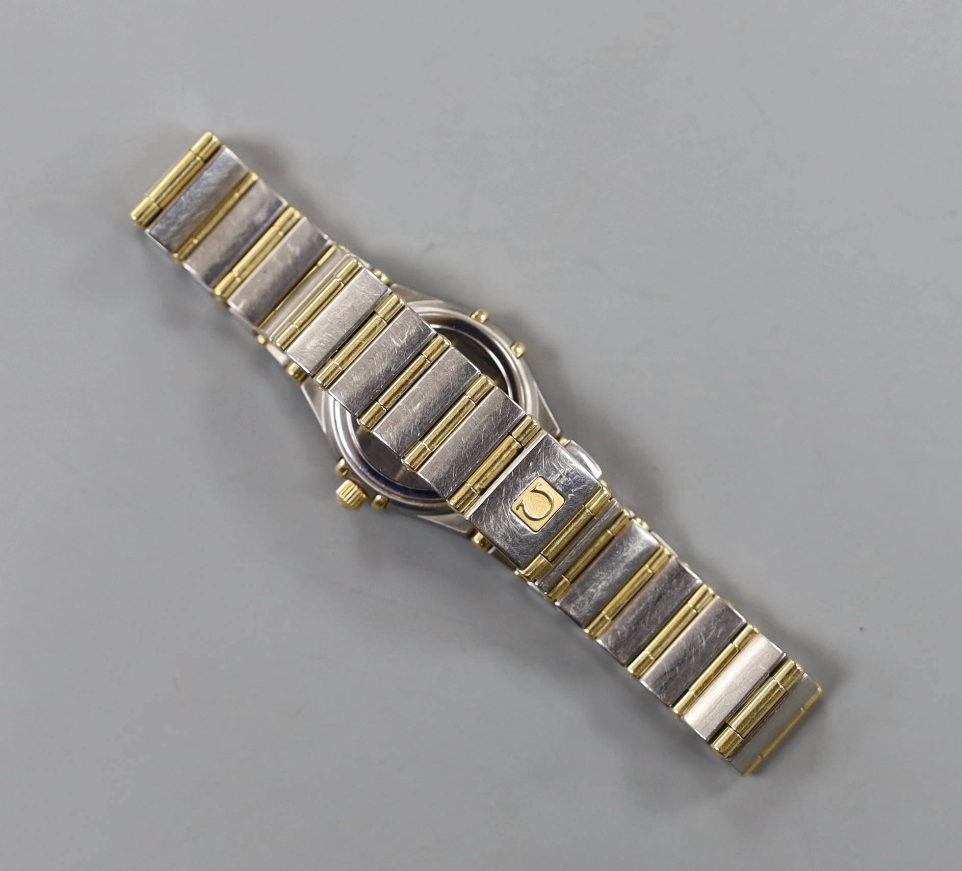 A lady's modern steel and yellow metal Omega Constellation quartz wrist watch and bracelet, with mother of pearl dial and diamond set bezel, with box and some papers, including precious gem certificate